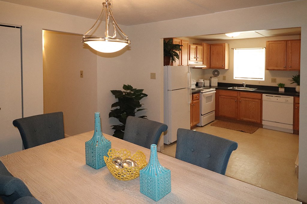 a dining room table with a kitchen in the background