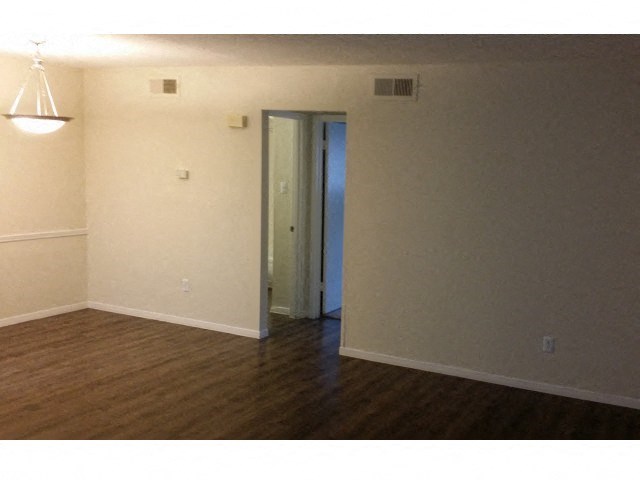 an empty living room with a door to a closet