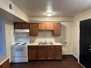 A kitchen with wooden cabinets and white appliances.