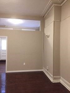 an empty living room with a wood floor and white walls