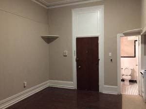 an empty room with a door and a bathroom