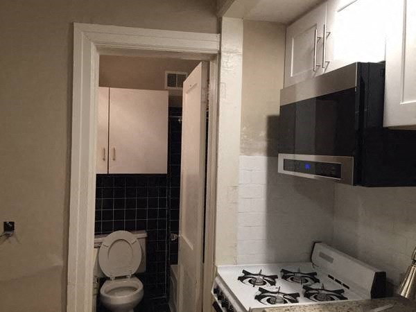 a small kitchen with a stove and a toilet