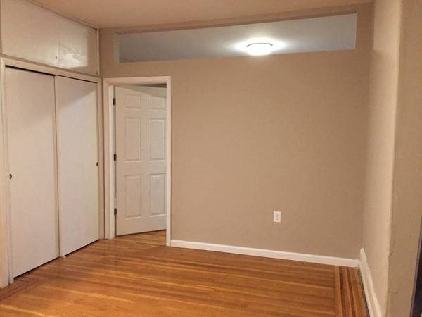 a empty room with a wooden floor and a white door