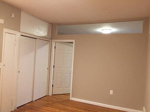 an empty room with white walls and a light on the ceiling