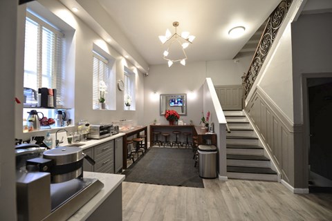 a kitchen with a staircase and a dining room with a table and chairs