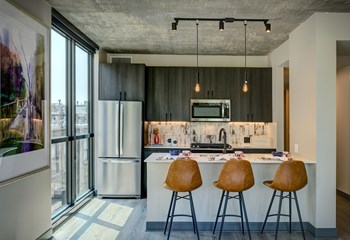 kitchen apartment featuring peninsula seating, pendant lighting, and modern appliances - Photo Gallery 3