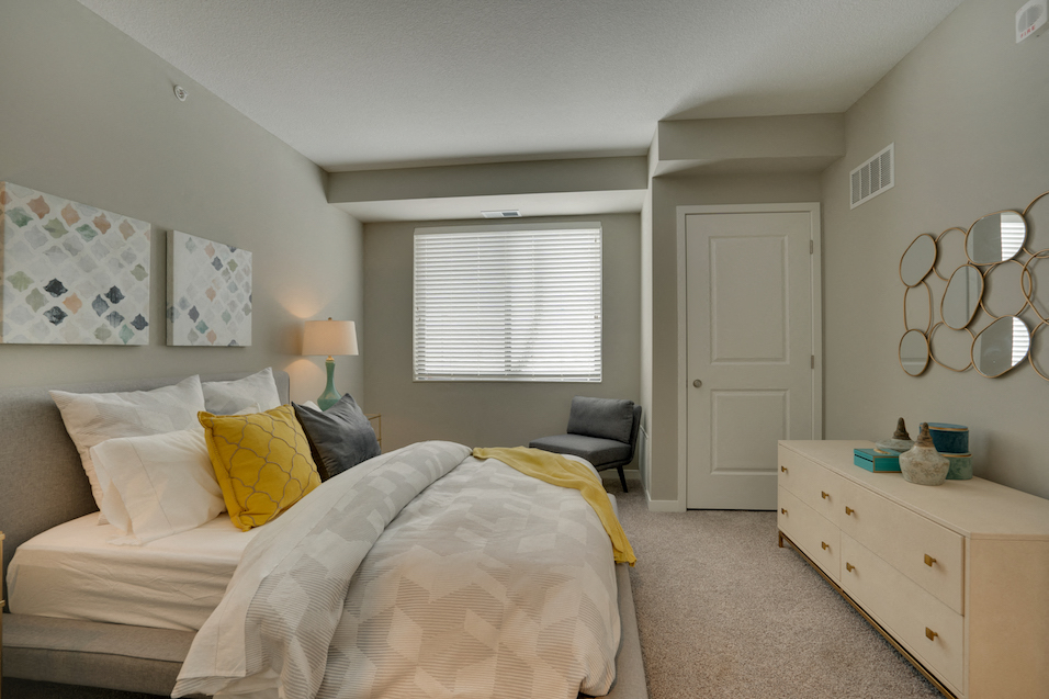 Bedroom with bed, dresser, closet door, and wall art