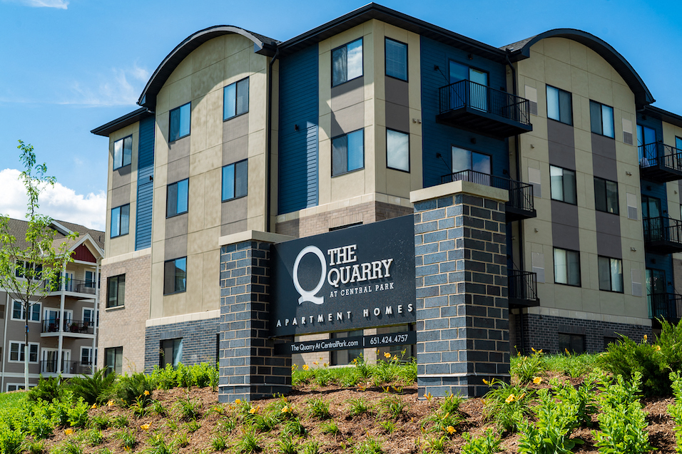 a large apartment building with a sign for the quality apartments at anthem towers