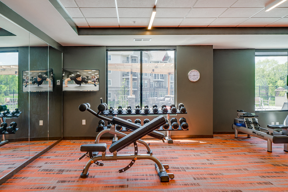 a workout room with weights and a large window