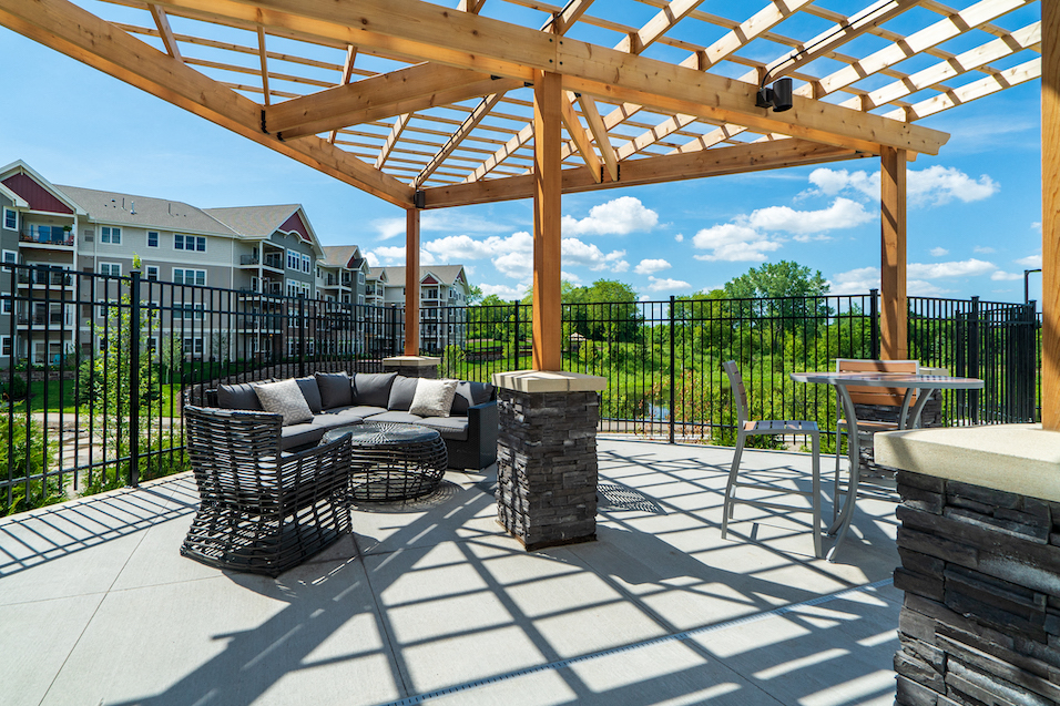 an outdoor patio with furniture and a pergola