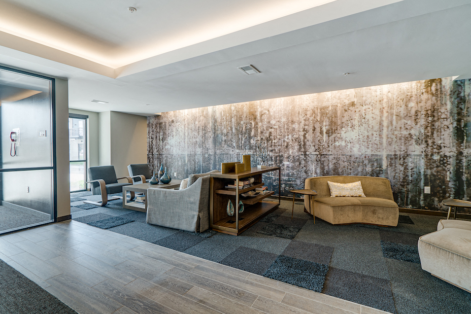 a living room with couches and chairs and a wall with a painting on it