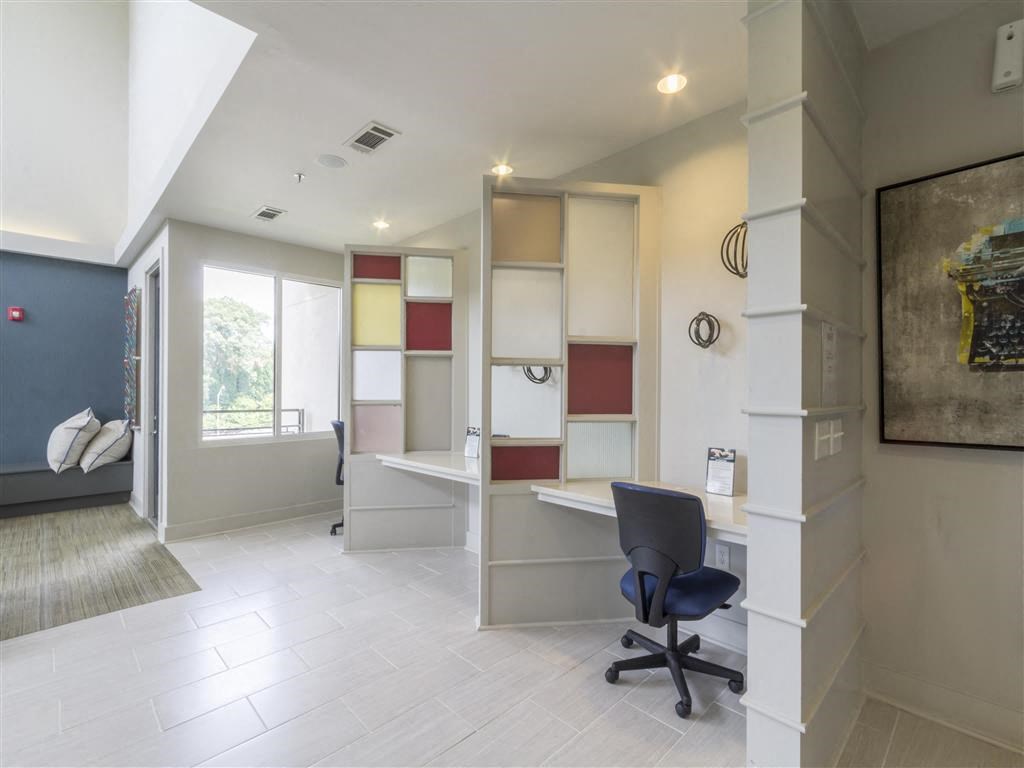 an office with a desk and a chair in a room with a bed