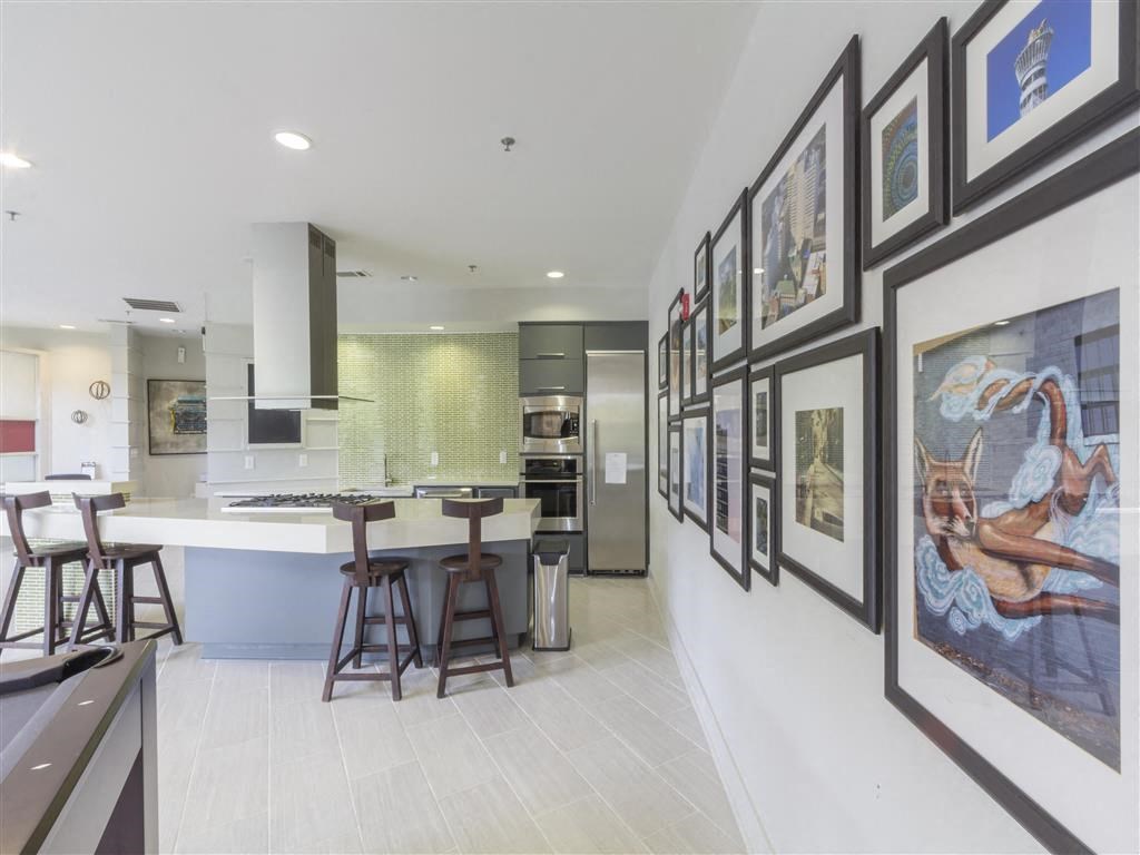 a kitchen with a bar and pictures on the wall