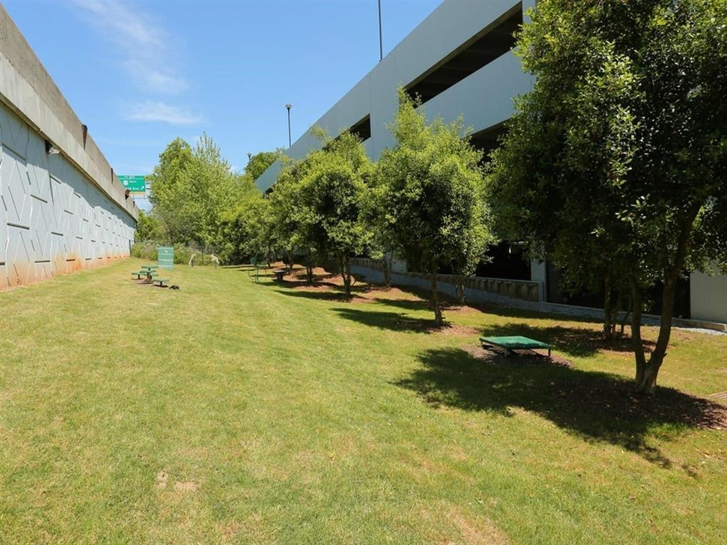 a park with trees and picnic tables in front of a building