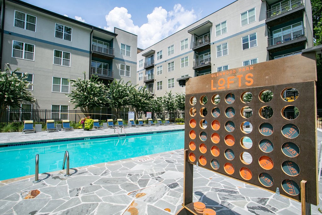 a game board next to a swimming pool with an apartment building