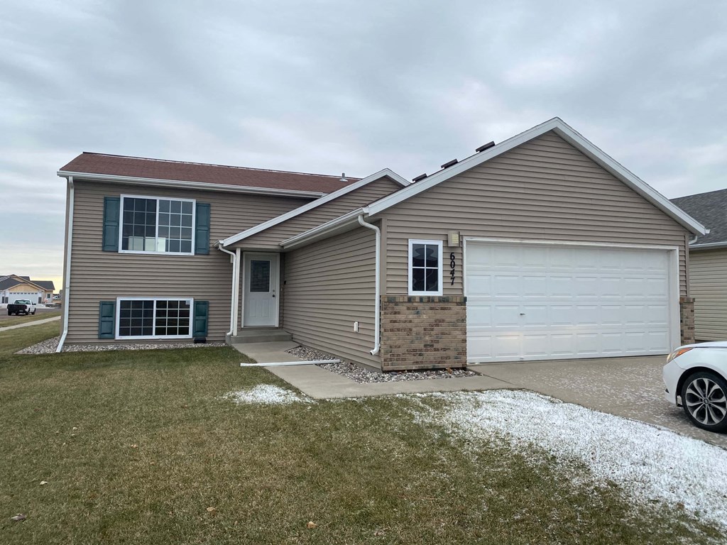 A house with a white garage door and a grey roof.