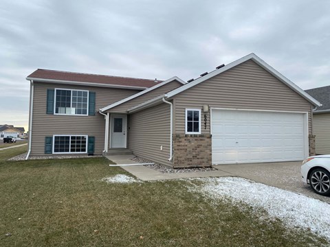 A house with a white garage door and a grey roof.