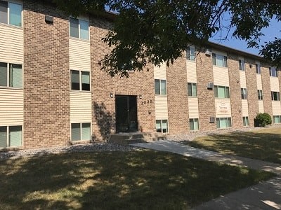 A brick building with a black door and windows on the side.