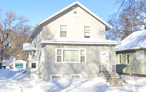 A house with a snow-covered front yard.