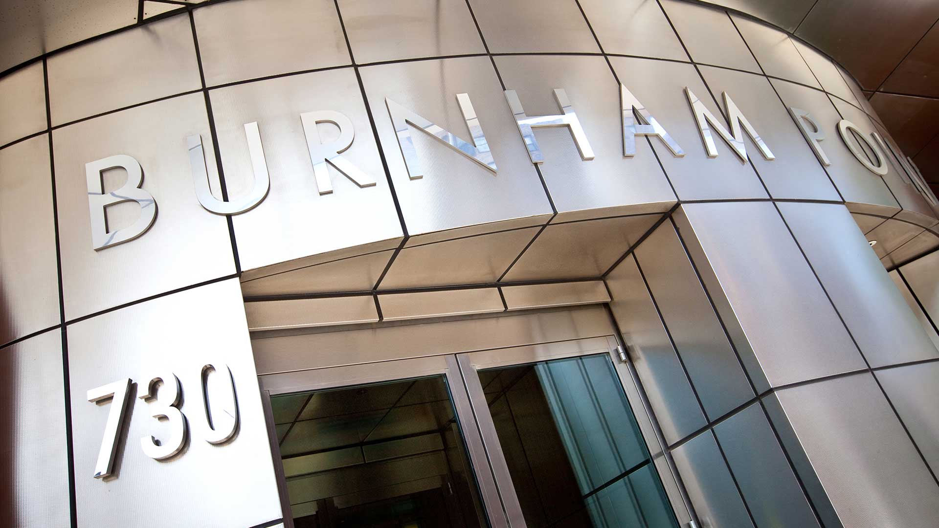 Looking up at the silver address and "Burnham Pointe" sign above the entry door to the apartment tower.