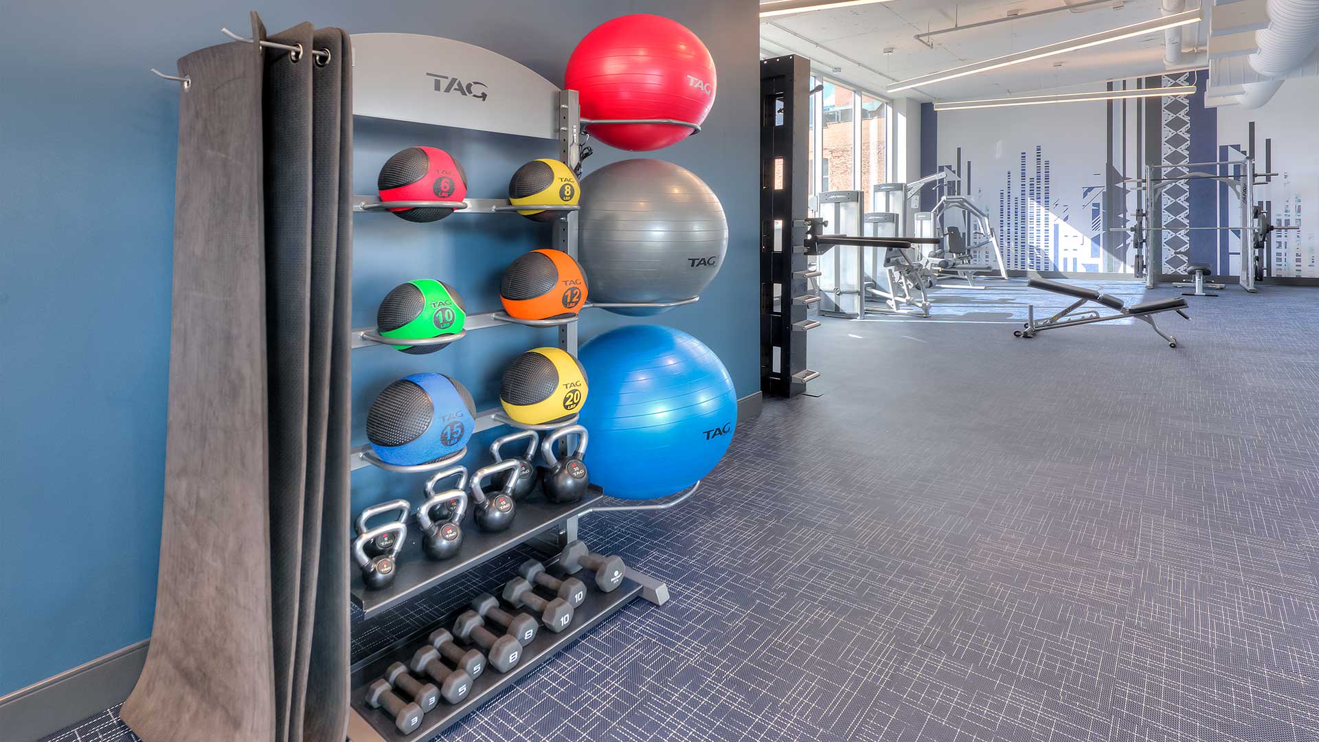 Various weights and exercise balls are stored on the left. Further down we see more exercise equipment set-up.