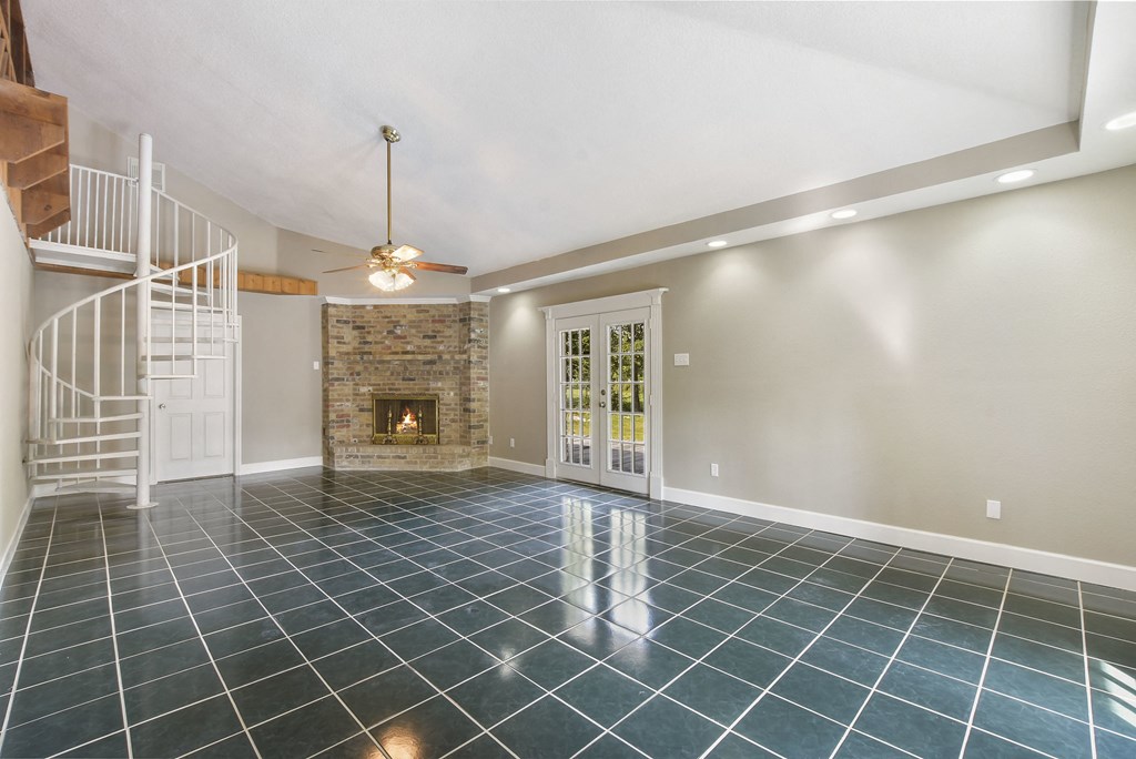 an empty living room with a fireplace and a staircase