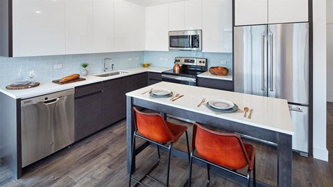 a kitchen with a white counter top and stainless steel appliances
