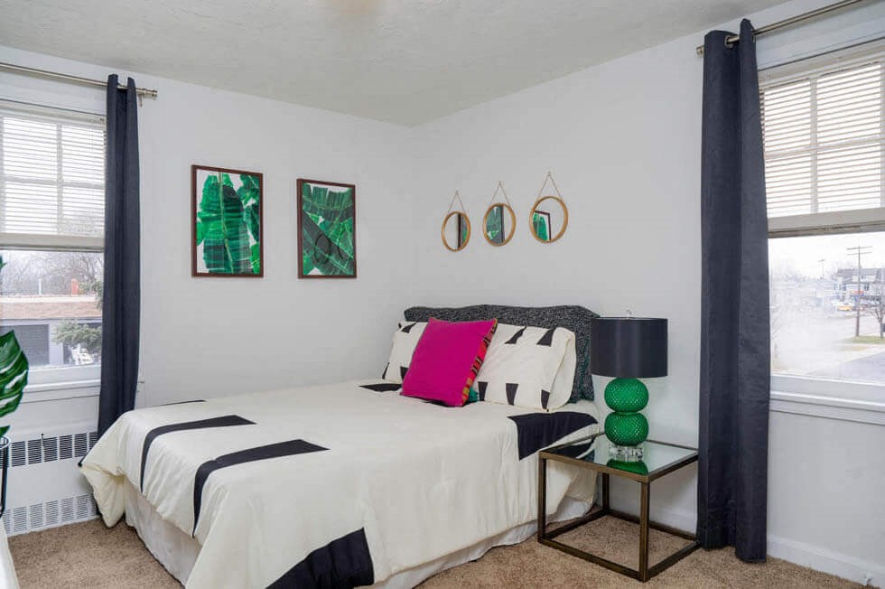 a bedroom with a bed and two windows