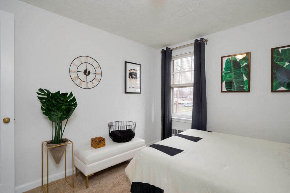 a bedroom with a bed and a clock on the wall