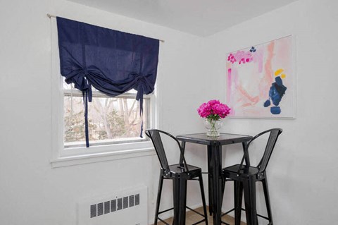 a dining room with two stools and a table next to a window