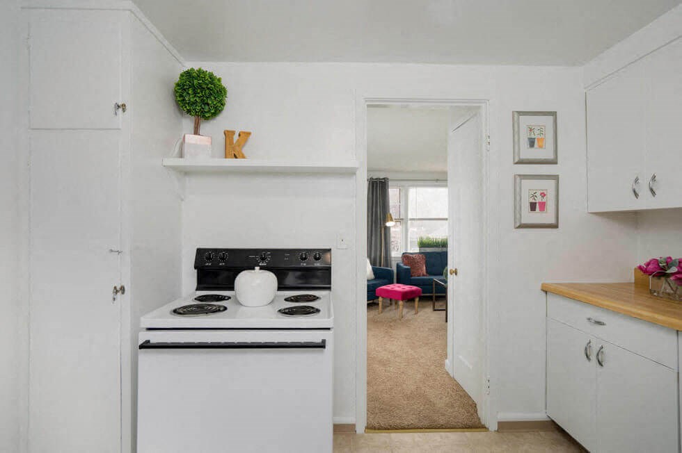 a white kitchen with a stove and a sink