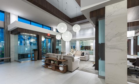 A modern living room with a white sofa and a glass coffee table.
