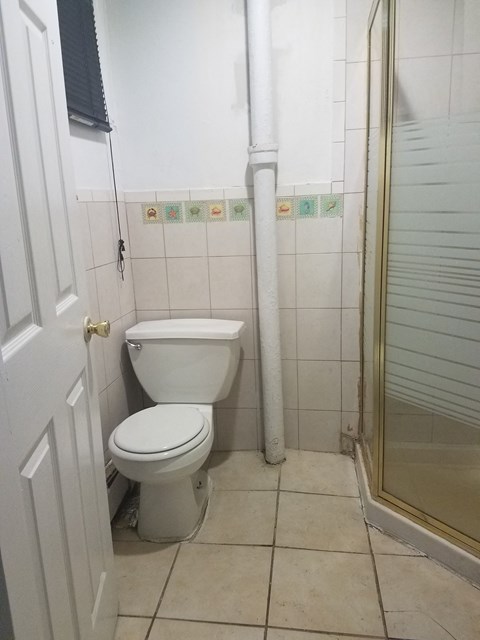 A white toilet in a small bathroom with a white door.