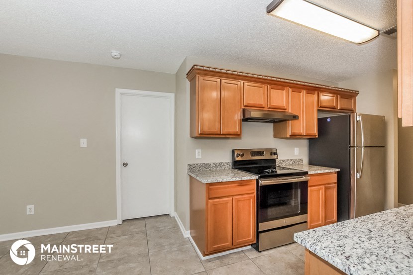 a kitchen with wooden cabinets and stainless steel appliances
