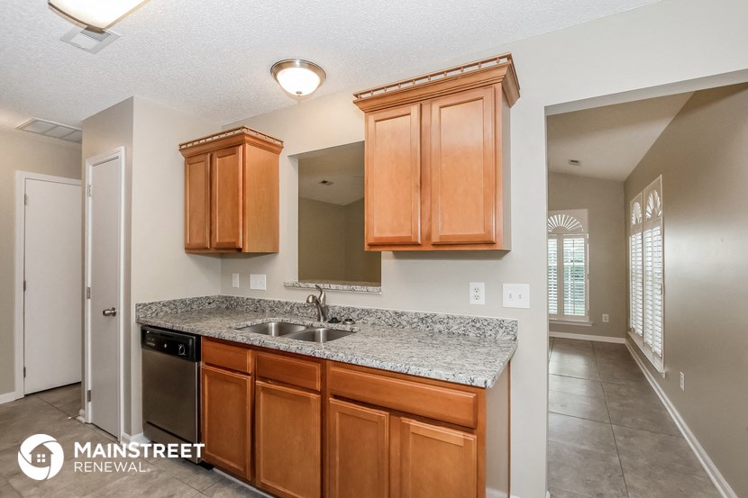 a kitchen with wooden cabinets and granite counter top and a sink