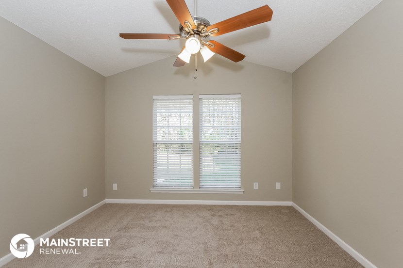 a bedroom with a ceiling fan and a window