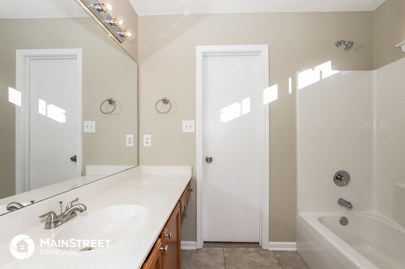 a bathroom with a sink and a tub and a mirror