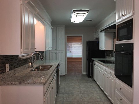 a kitchen with white cabinets and a sink