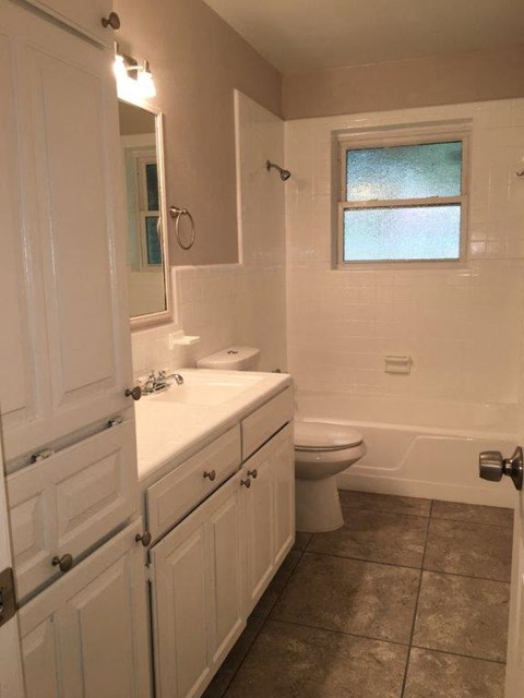 a bathroom with a toilet and a sink and a window