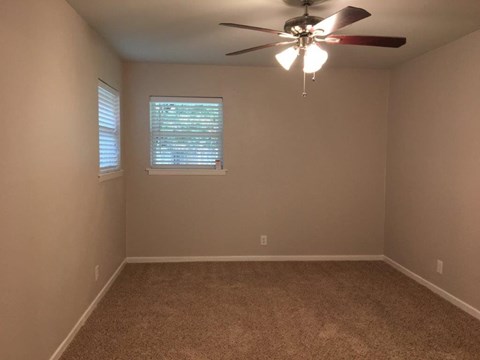 a empty room with a ceiling fan and a window