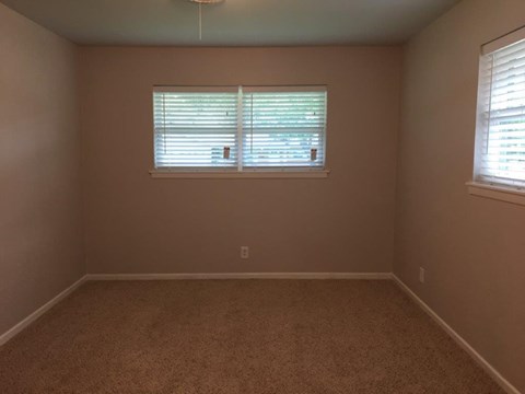 a empty room with a window and a carpet