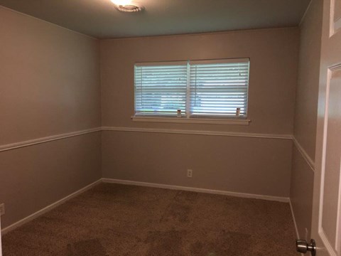 a small room with a window and a carpet