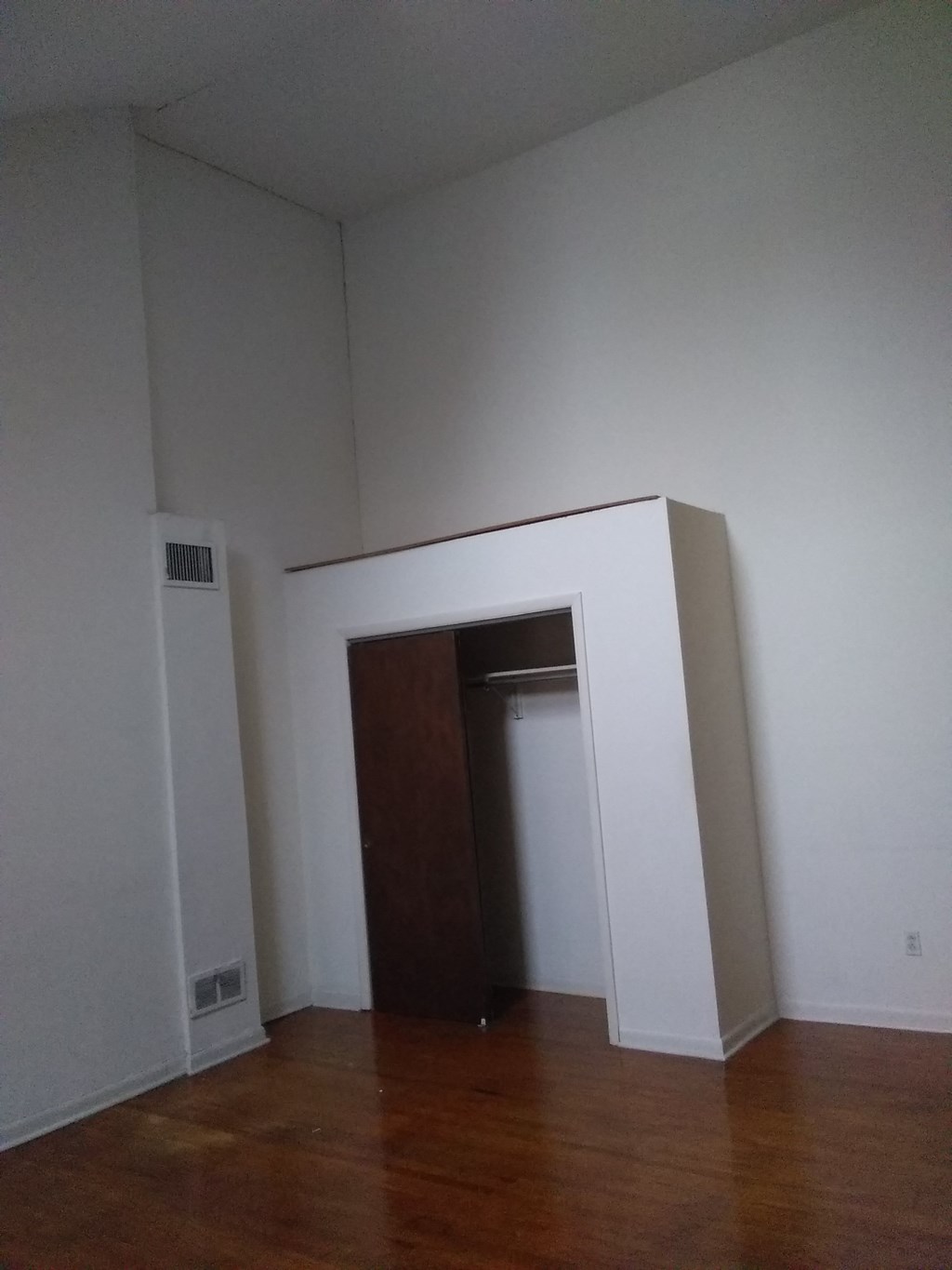 an empty room with a door and a closet