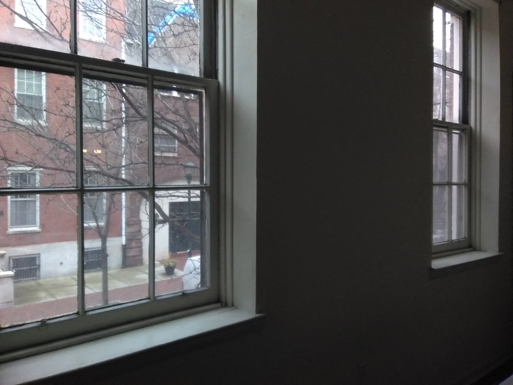 a window with a view of a street and a brick building