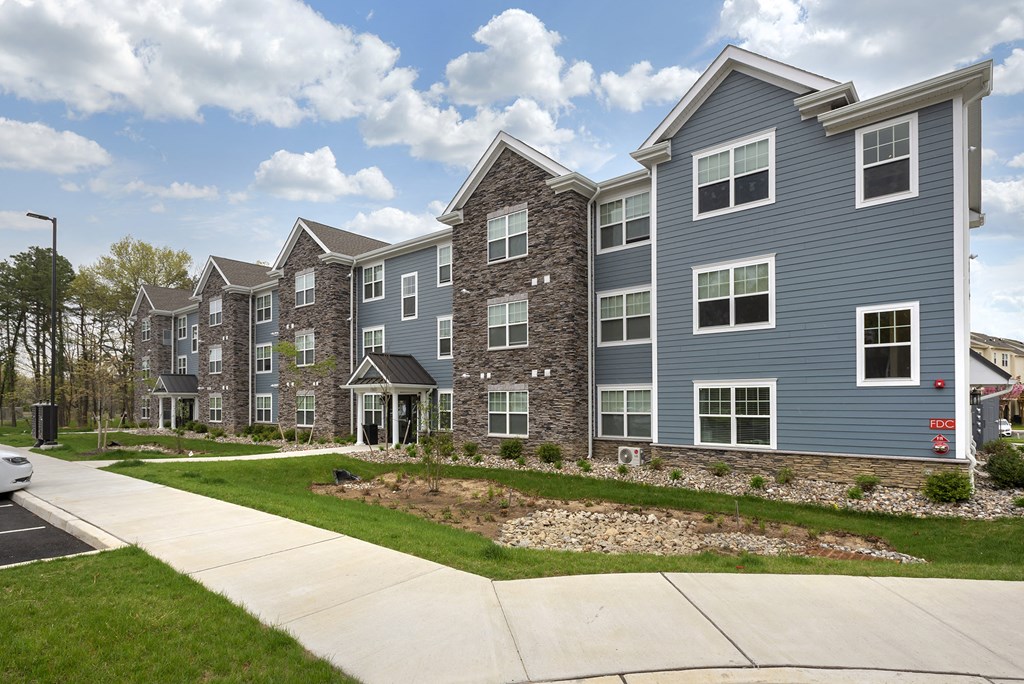 an exterior view of an apartment building with a sidewalk
