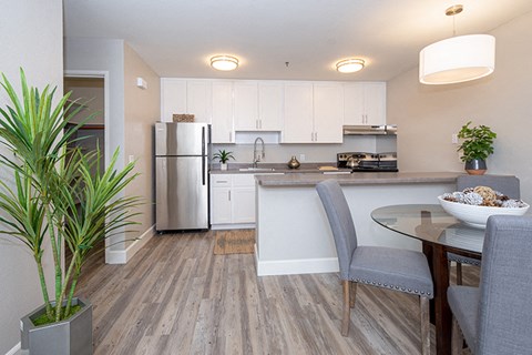 a kitchen and dining room with a stainless steel refrigerator
