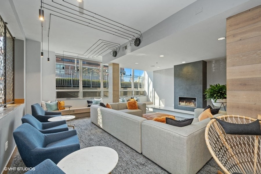 a living room with a couch and chairs in front of a fireplace
