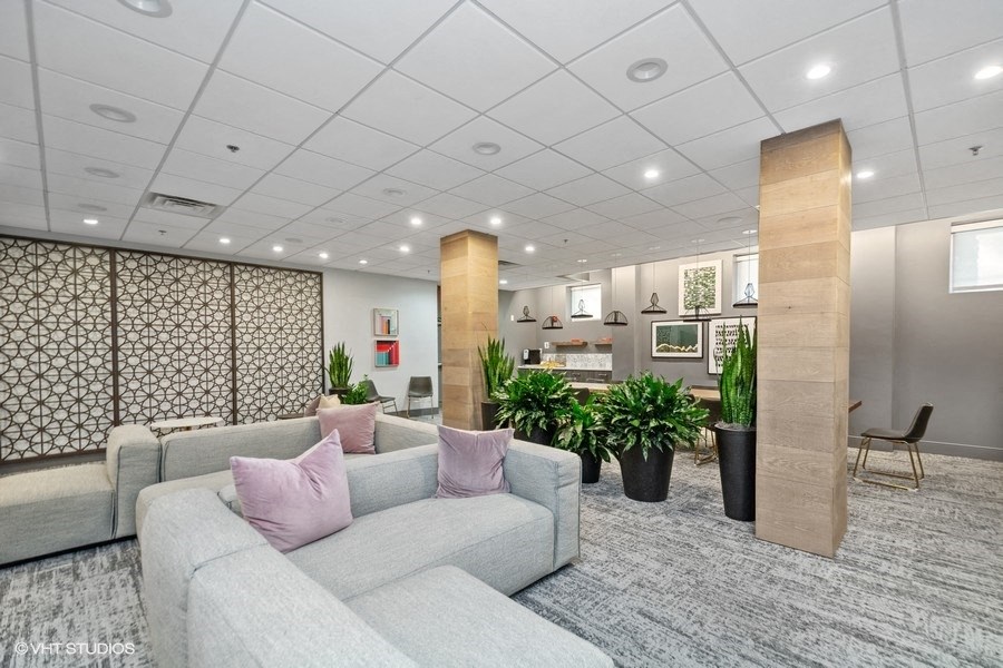 a large room with couches and potted plants