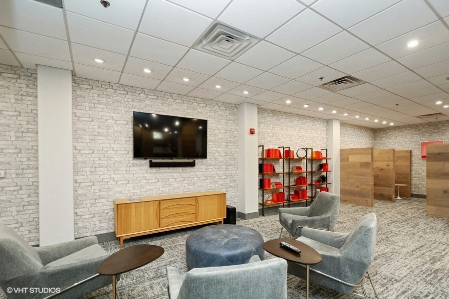 a room with chairs and a tv on the wall