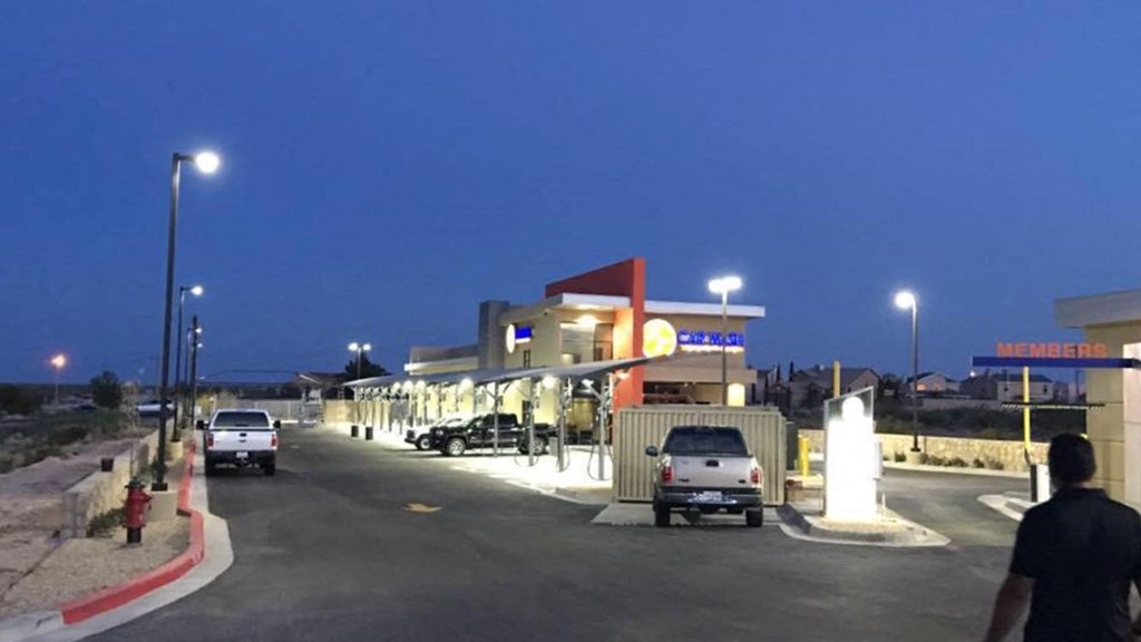 a gas station with cars parked in front of it at night